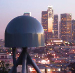 a dome on top of a tripod with a high-rise buildings in the background